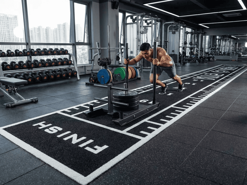 Man cleaning gym turf with correct equipment